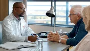 Older adult couple speaking with doctor in office